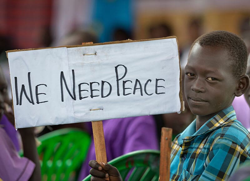 A boy holds a sign at a church-sponsored women's peace rally in Juba, South Sudan. Photo by Paul Jeffrey www.kairosphotos.com